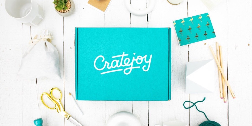 Branded teal Cratejoy subscription box in a lifestyle flat-lay