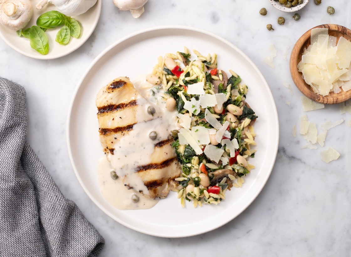 BistroMD fully prepared heat-and-eat meal plated: grilled chicken in caper cream sauce with vegetable orzo